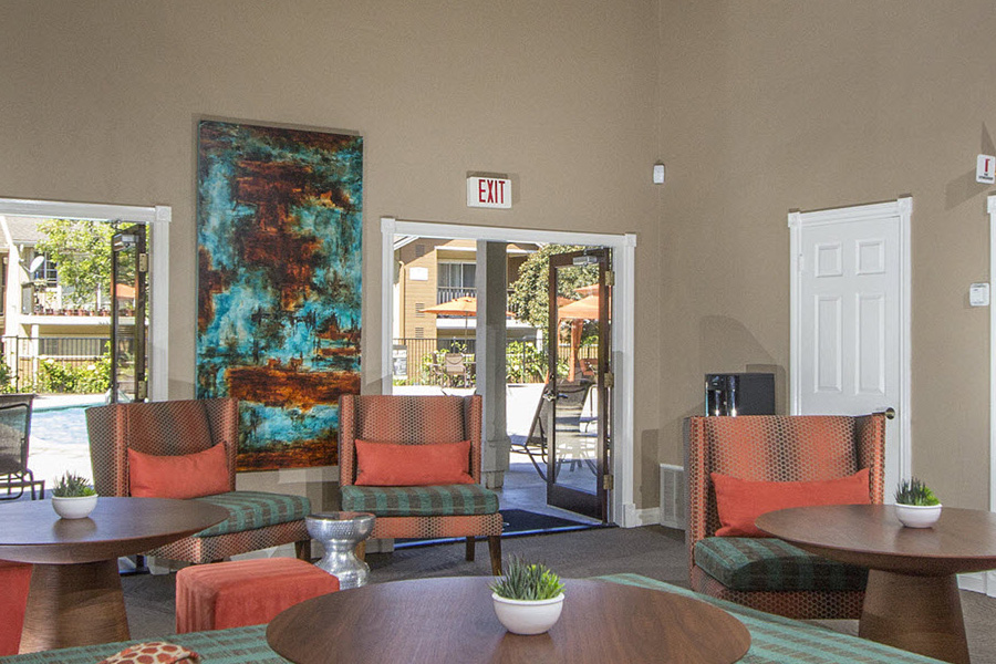 large lounge room with double doors open to the pool patio and an array of orange and teal striped luxury chairs
