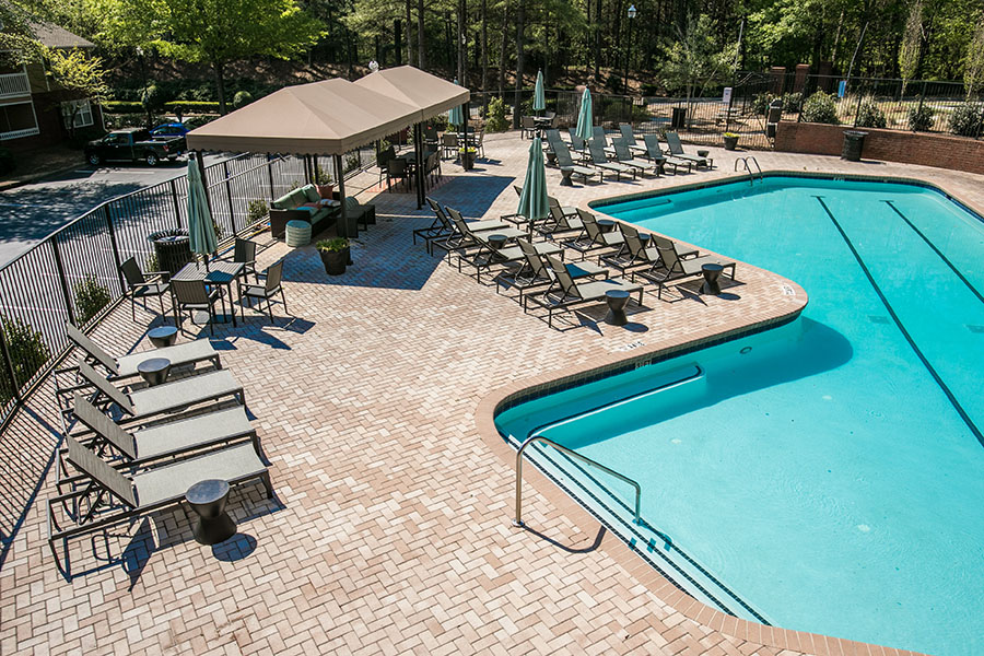Overhead view of pool area with bright blue pool, gazebo, and lounge furniture.