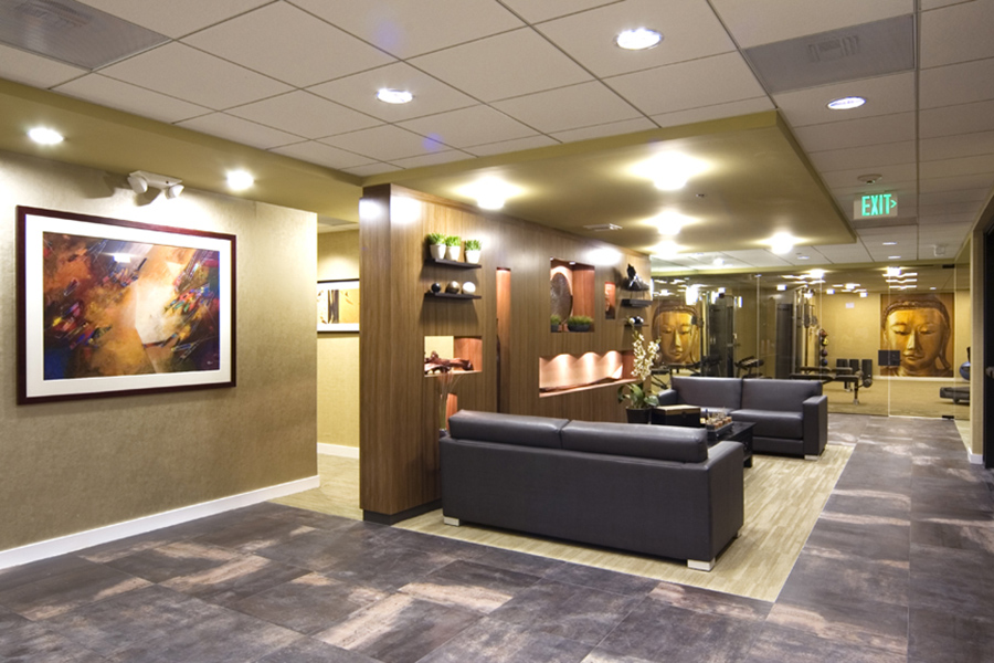 Lounge area with artwork, patterned carpet floors, and comfortable leather couches.