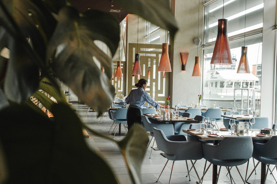 modern dining restaurant with large windows, granite tables, and grey chairs
