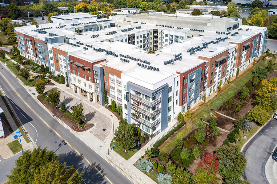 Aerial view of 4 story IMT at the Galleria apartments with central courtyards and lush landscaping.