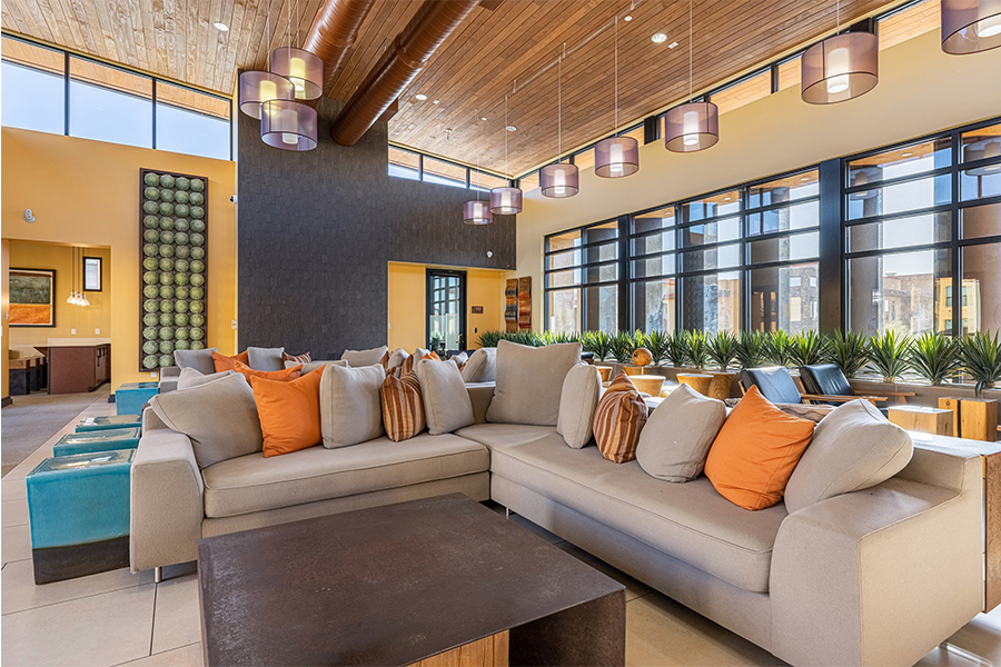 Clubhouse with plush seating, vaulted ceilings, and large windows.
