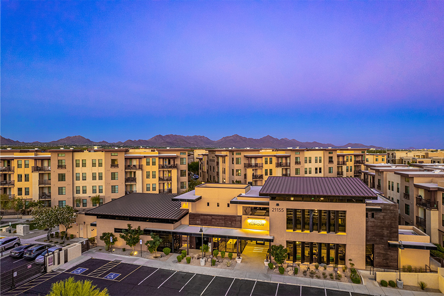 IMT Desert Ridge apartments at dusk with distant mountains.