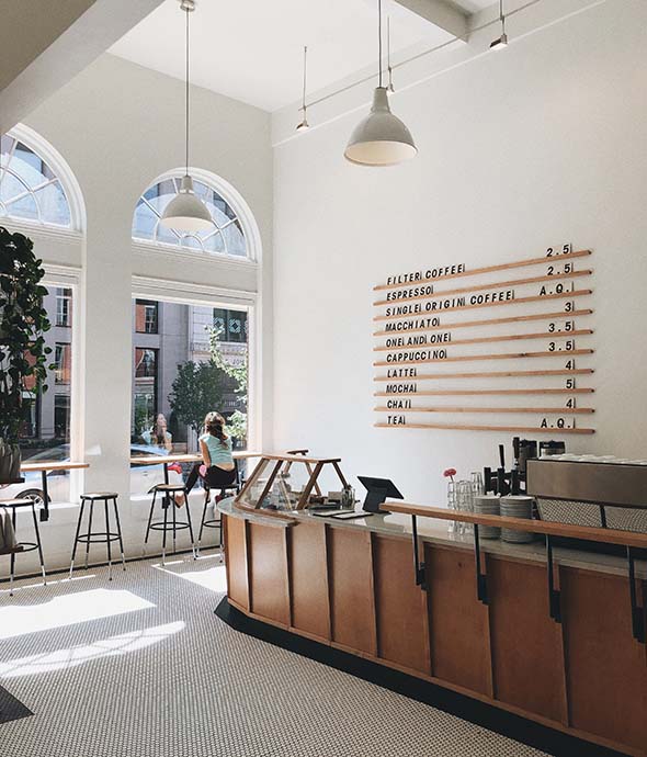 Coffee shop with large menu board and tall windows.